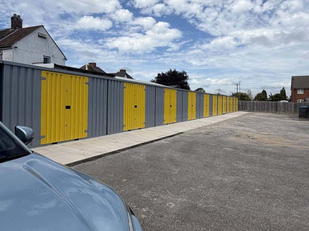 A long run of grey modular storage units with yellow doors in Street, Somerset
